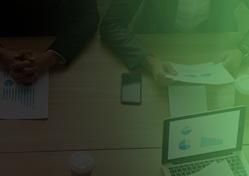 A diverse group of professionals collaborating at a table, each using laptops, focused on digital marketing strategies.